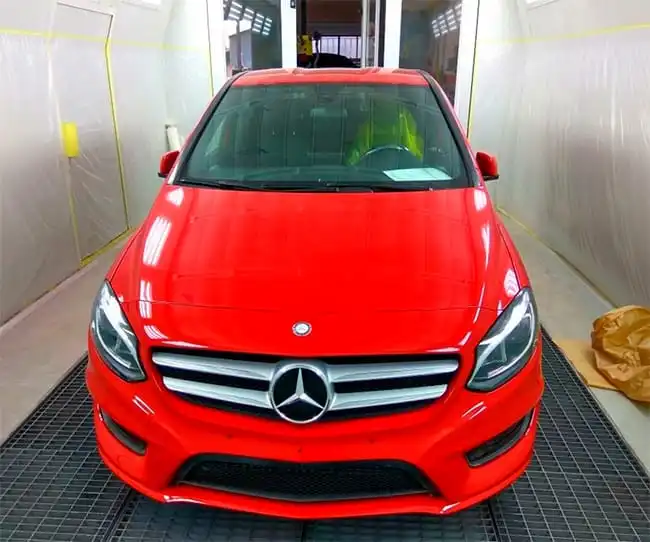 Qué tipo de carrocerías utilizan los vehículos actuales en coche rojo dentro de un taller de chapa y pintura