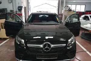 Talleres de chapa y pintura en Valencia con coche Mercedes negro en reparación dentro del taller