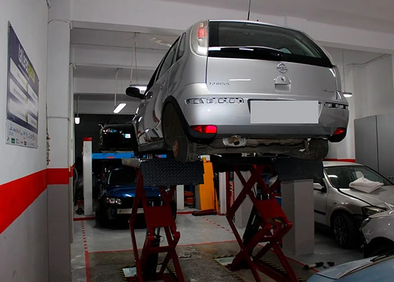 Vehículo elevado para su revisión en un taller próximo a Benicalap