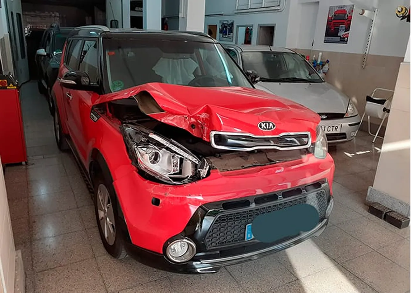 Reparación de golpe frontal en coche rojo Kia rojo con golpe frontal pendiente de reparación