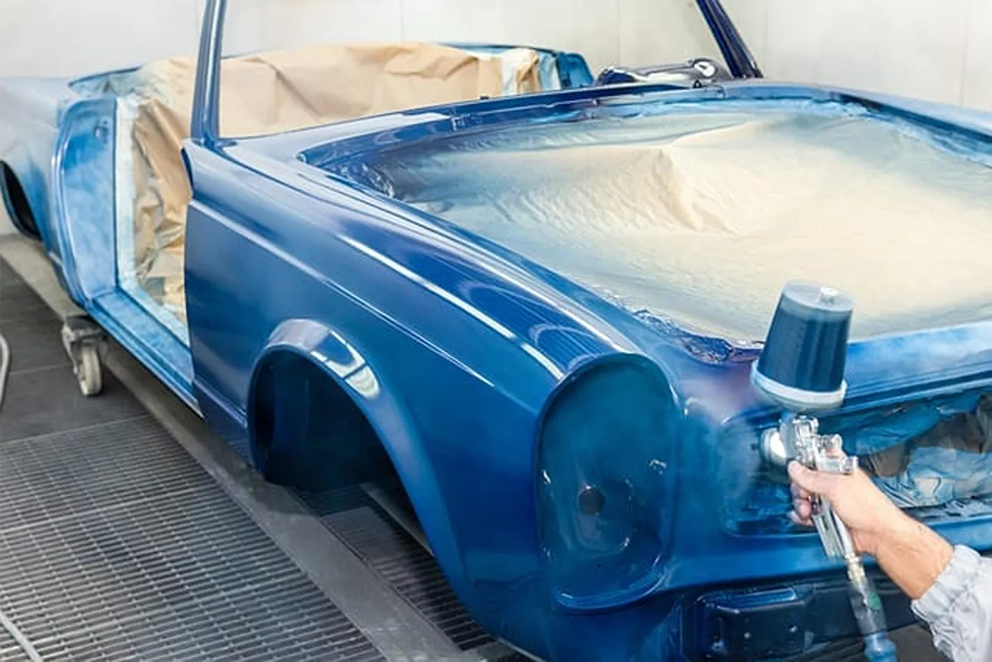 Proceso de pintura profesional en coche azul