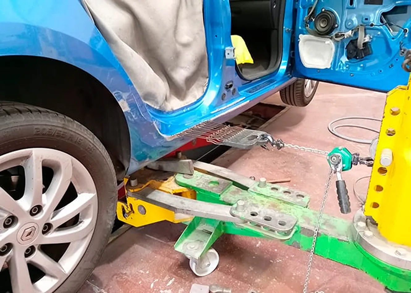Reparación de chapa en coche azul dentro del taller